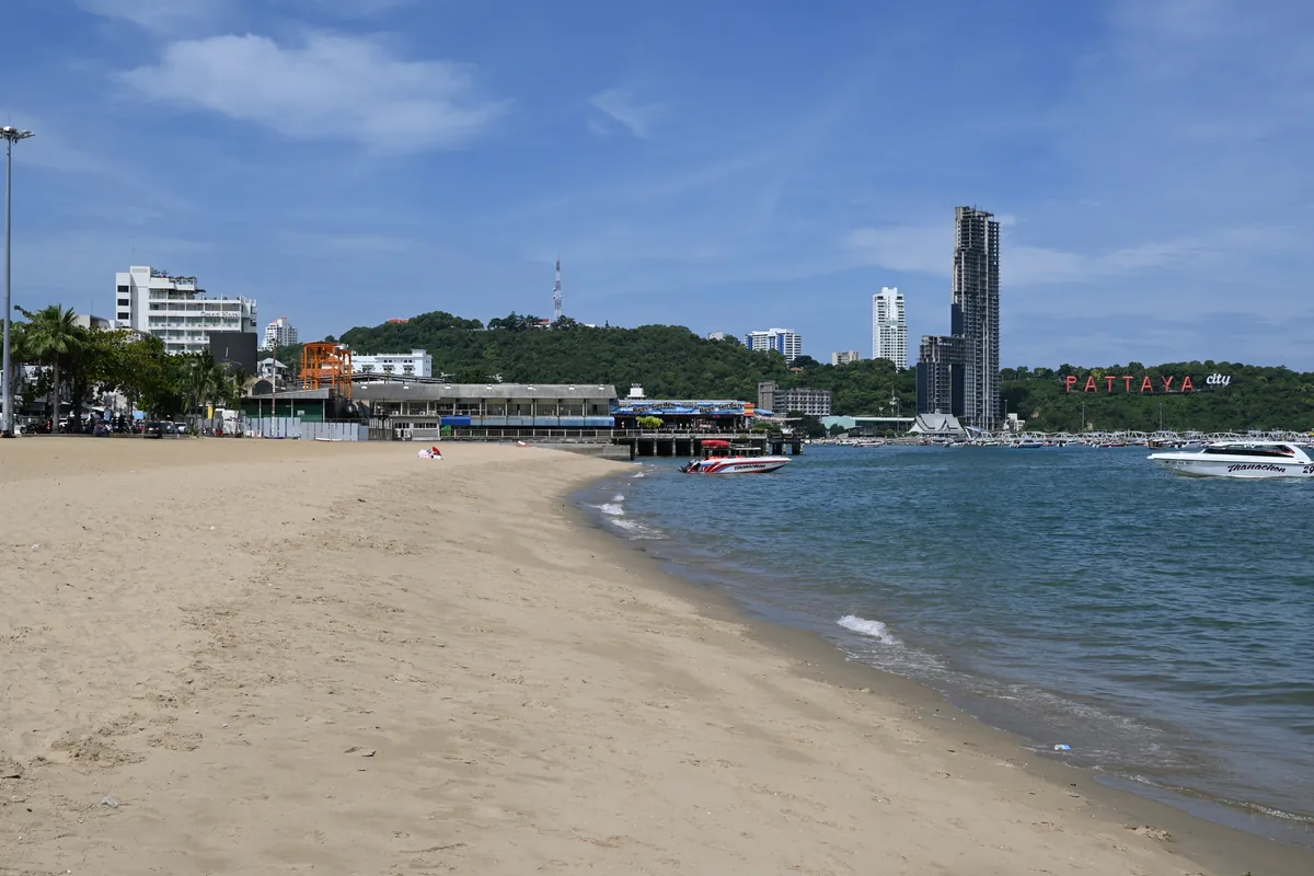 Blue water beside Pattaya Beach, with the Pattaya city sign across the bay